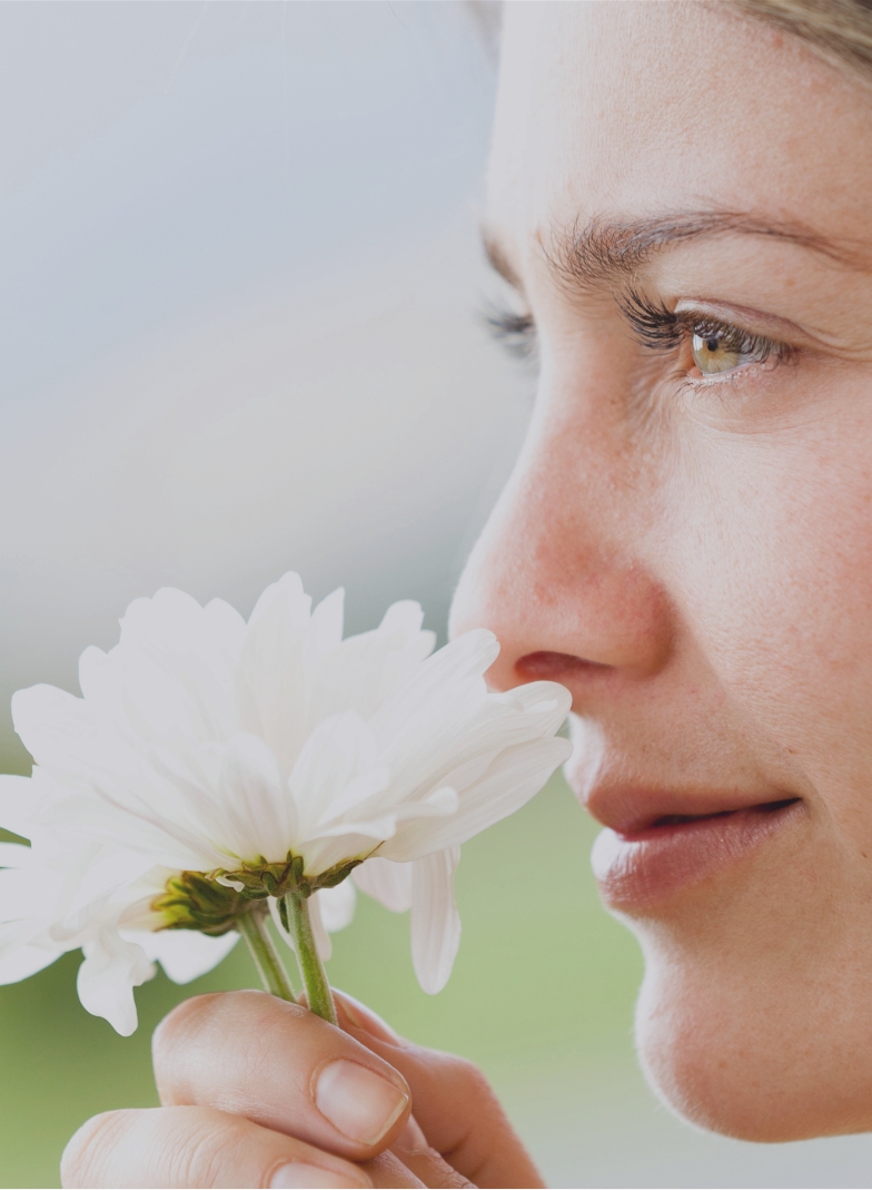 a person smelling a flower
